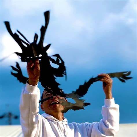 青空を背景に切った龍を持つじょじょすけ